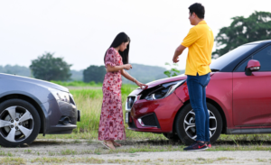 Automobile Accident with red and grey car and two person
